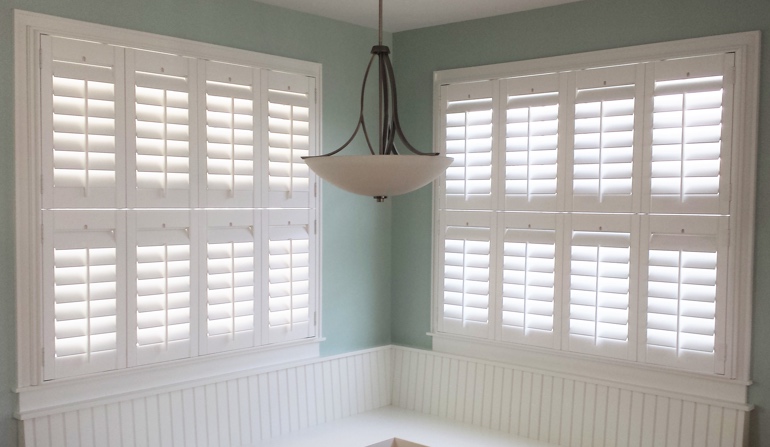 Pastel green wall in New York kitchen with shutters.